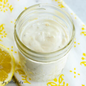 lemon yogurt dressing in a mason jar with a halved lemon next to it