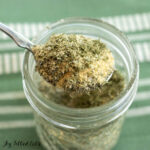 ranch dip mix recipe shown close up being held up on a spoon by a woman's hand