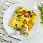 sheet pan omelet recipe serving on glass plate with bite on fork from overhead