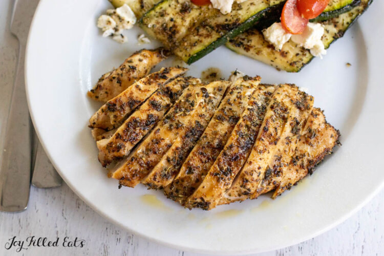 sliced grilled chicken with tuscan seasoning on dinner plate