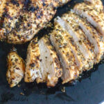 tuscan grilled chicken breasts sliced and whole on cutting board