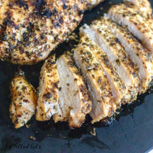 tuscan grilled chicken breasts sliced and whole on cutting board