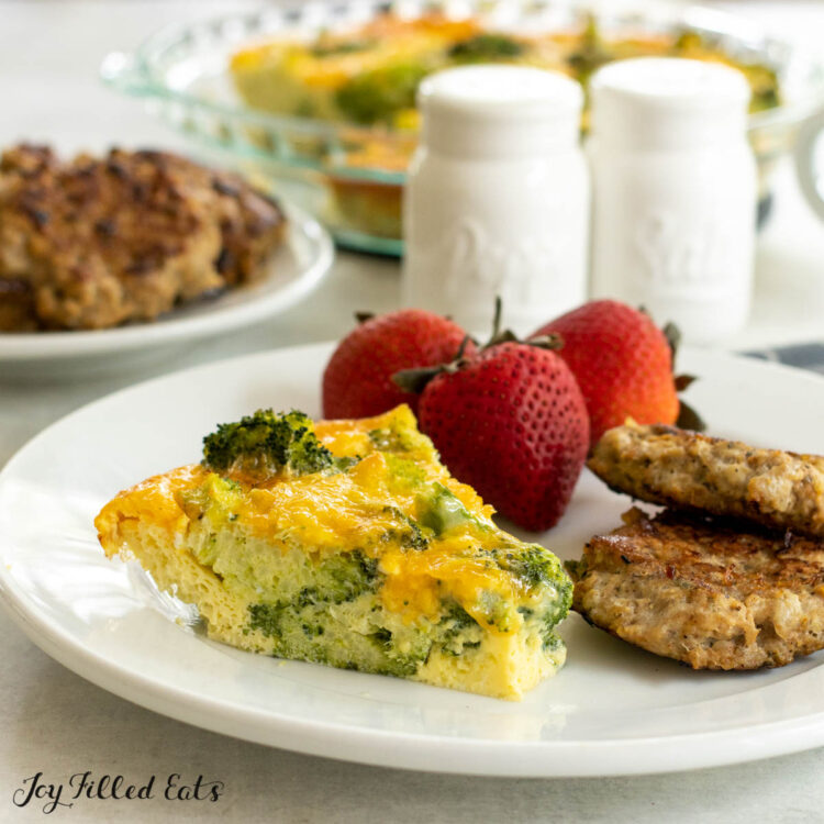 slice of crust less broccoli quiche on a plate with sausage