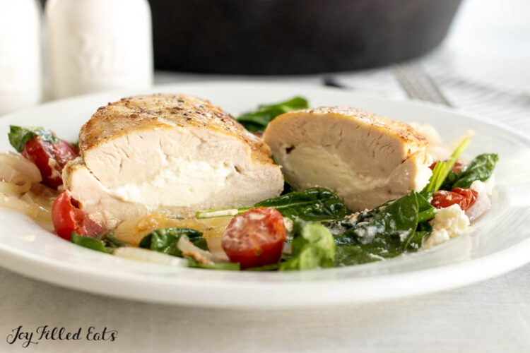 goat cheese stuffed chicken breast cut in half on dinner plate