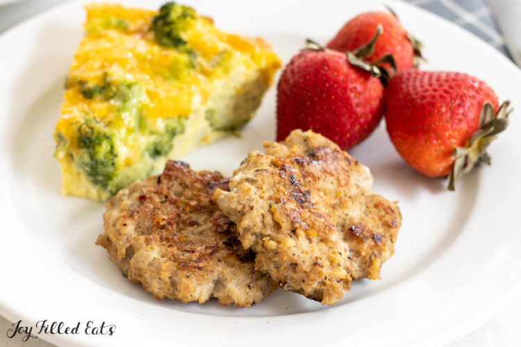 turkey breakfast sausage patties close up on a plate with quiche and strawberries