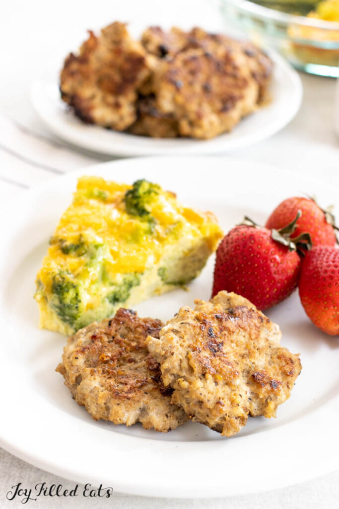 turkey breakfast sausage patties on a plate with quiche and strawberries