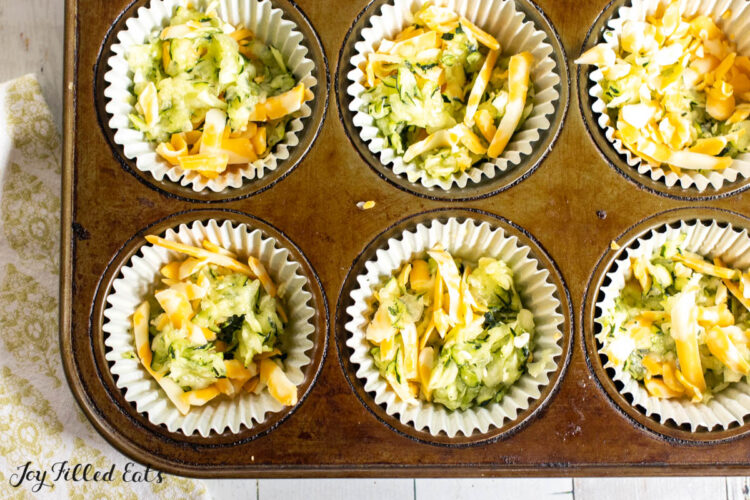 shredded zucchini and cheese in muffin cups