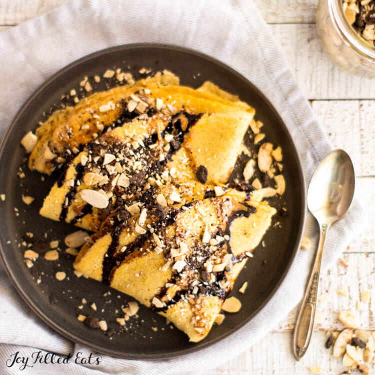 keto crepes recipe with almond flour close up served with chocolate drizzle and nuts