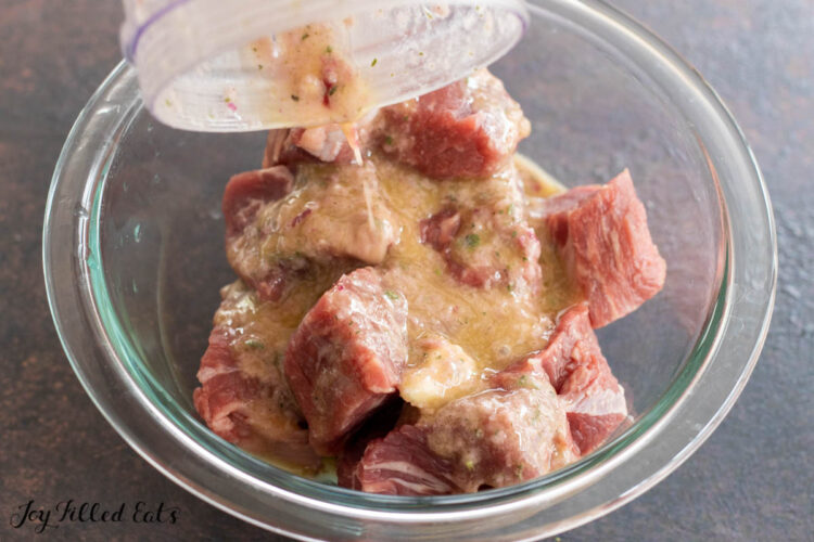 marinade being added to cubed beef
