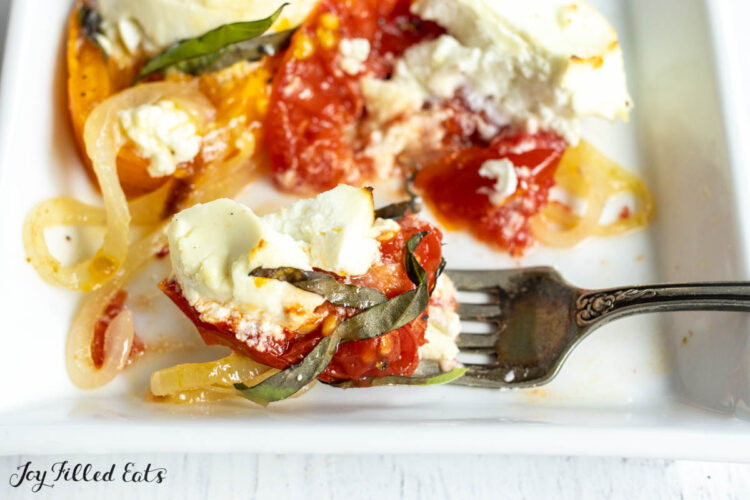 bite of baked goat cheese on a fork resting on appetizer plate