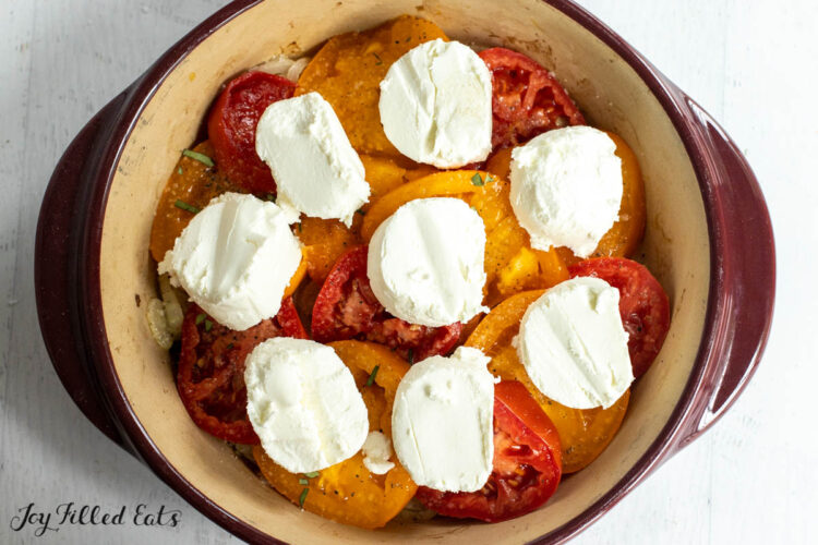 rounds of goat cheese added on top of the tomatoes