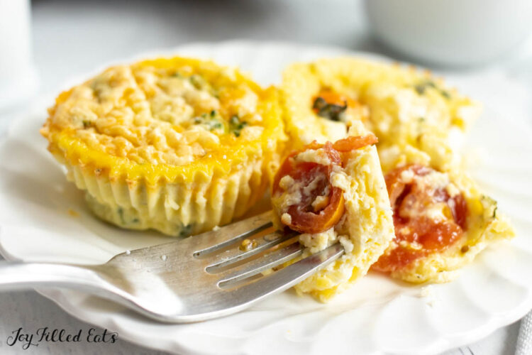 bite of egg with tomato and feta cheese on a fork