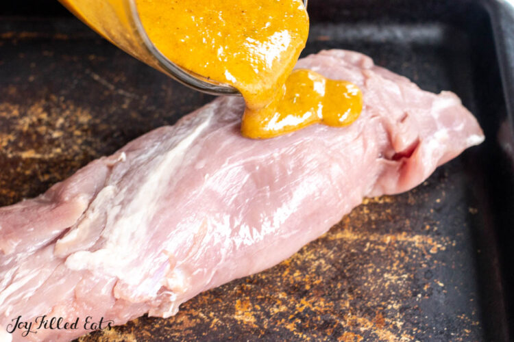 sauce being drizzled over meat