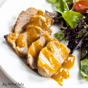 honey mustard pork tenderloin sliced on a dinner plate close up