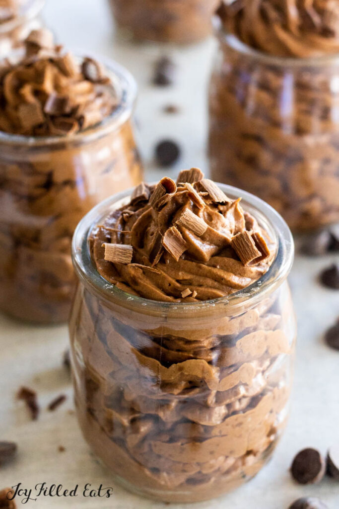 keto chocolate mousse piped into a glass jar with chocolate shavings close up