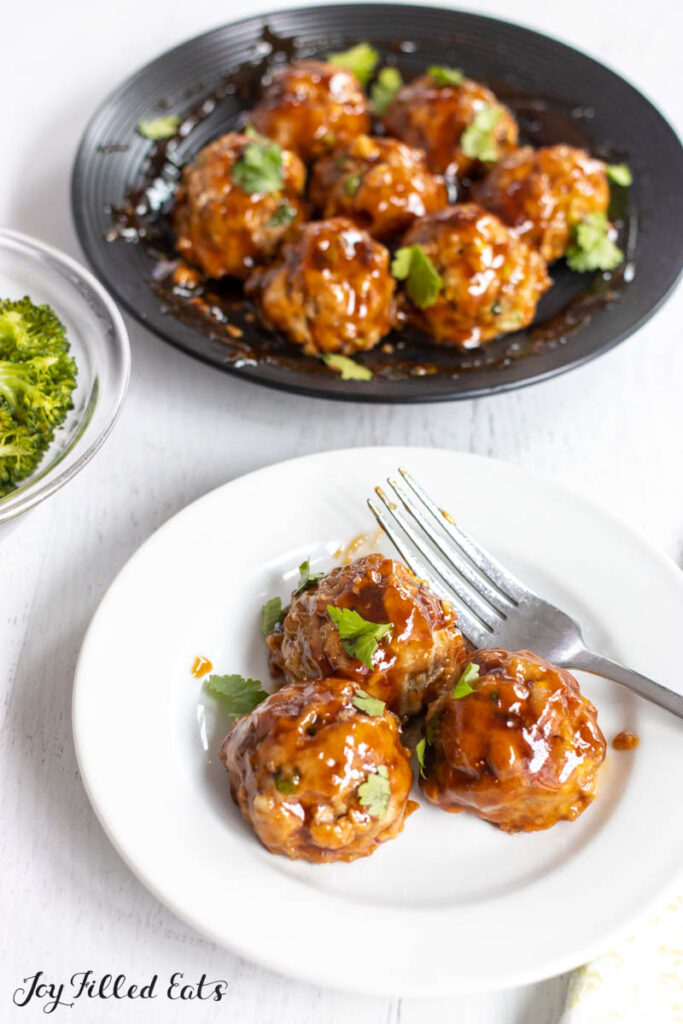 small plate with three meatballs with platter behind