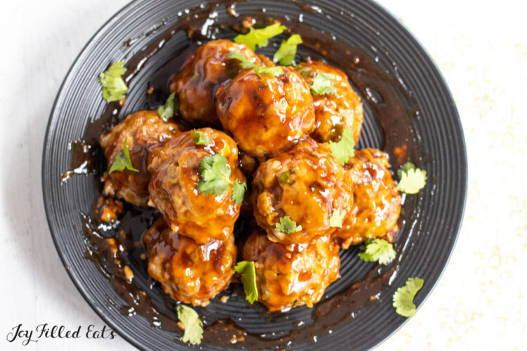 thai pork meatballs on black plate from overhead
