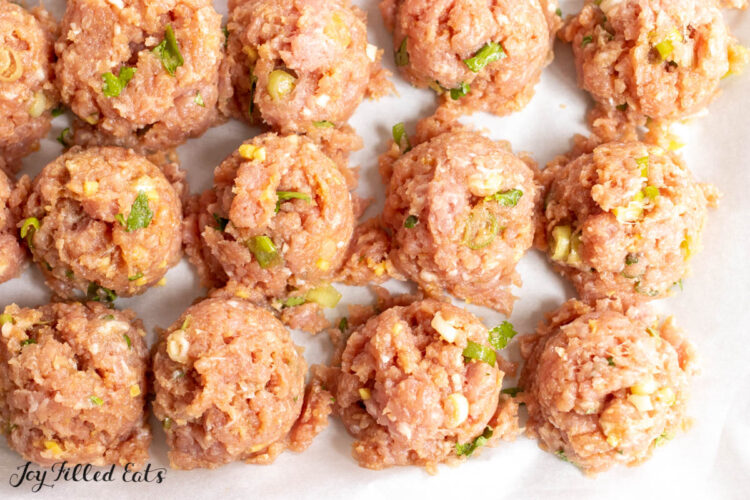 raw meatballs on parchment lined pan